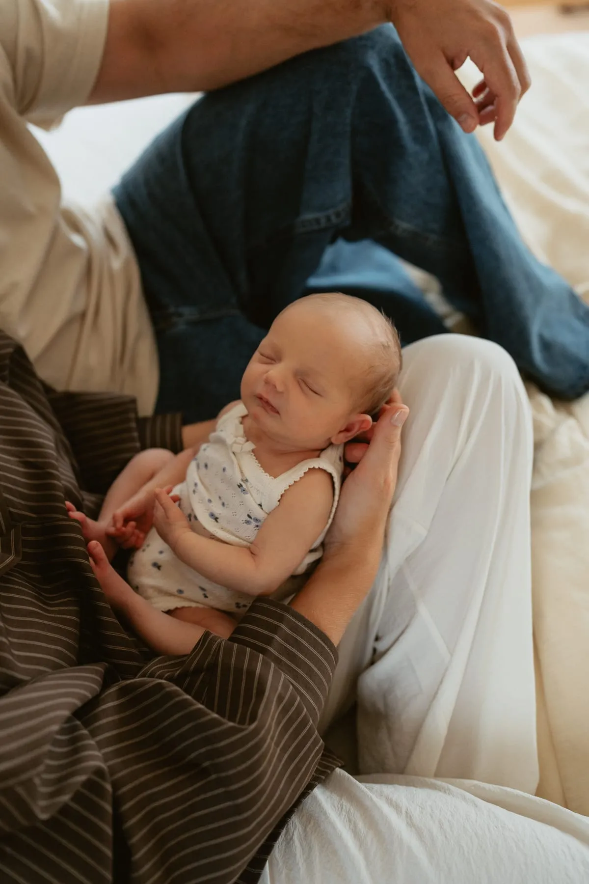 A newborn resting on her dad’s lap